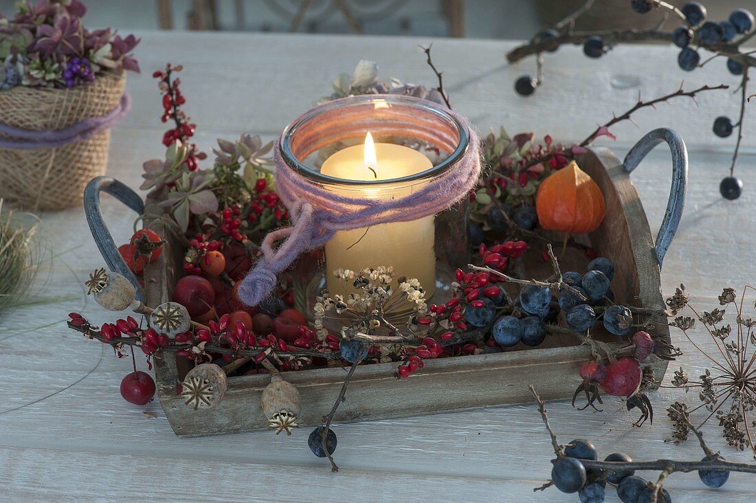 Wooden tray with autumn fruits and a lantern