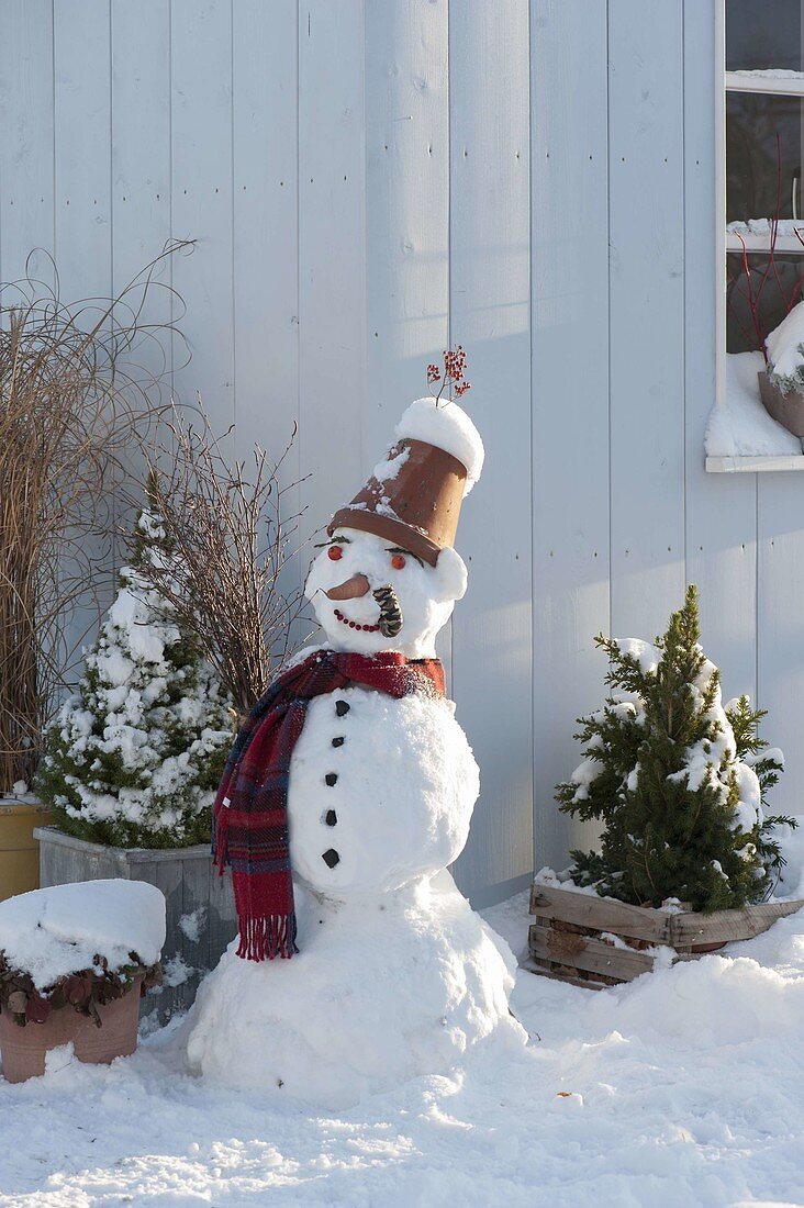 Schneemann mit Tontopf als Hut, Schal, Kohlstrunk als Pfeife, Karotte als Nase