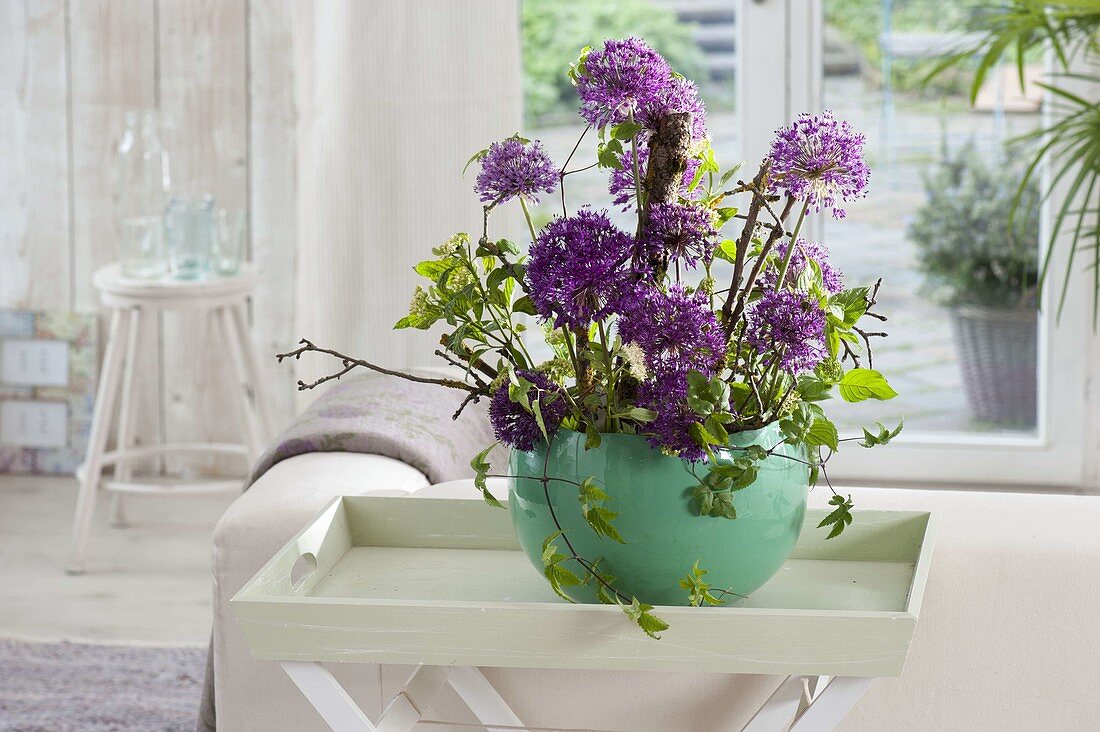 Modern flower arrangement with Allium 'Purple Sensation' (ornamental leek), twigs