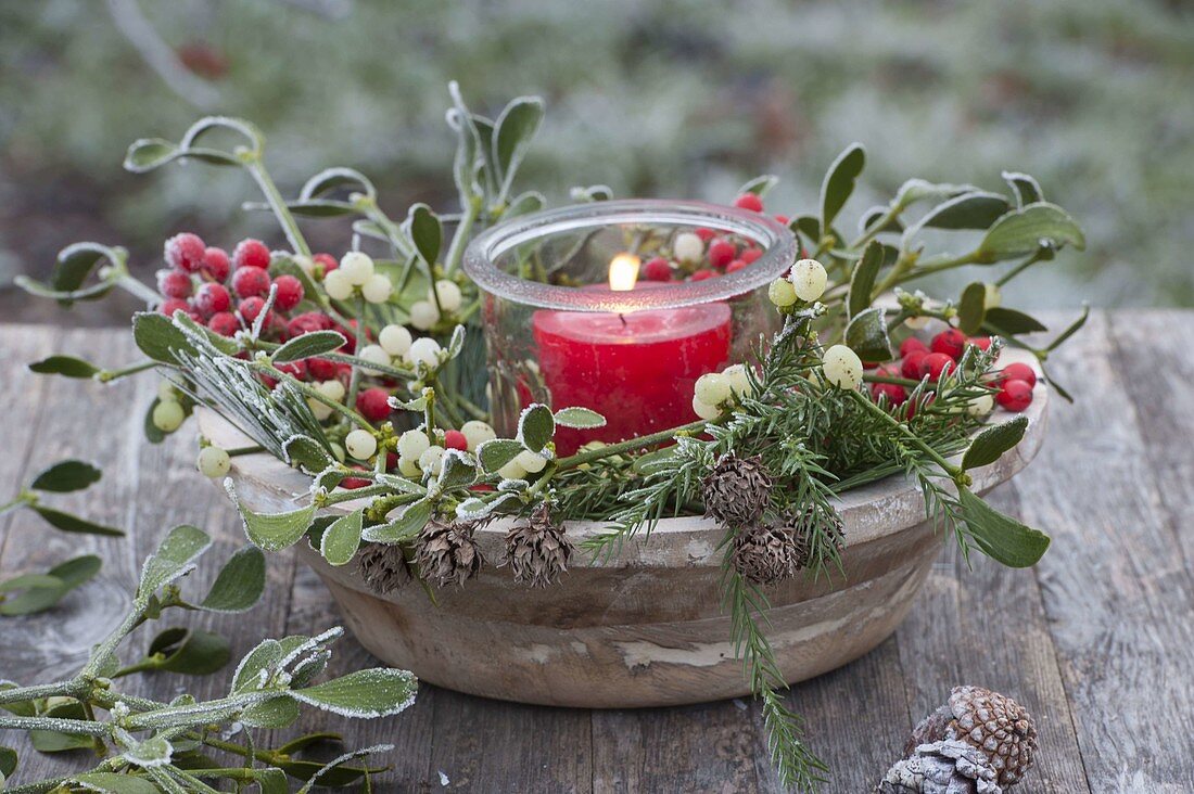 Lantern in wooden bowl with Viscum album (mistletoe) branches