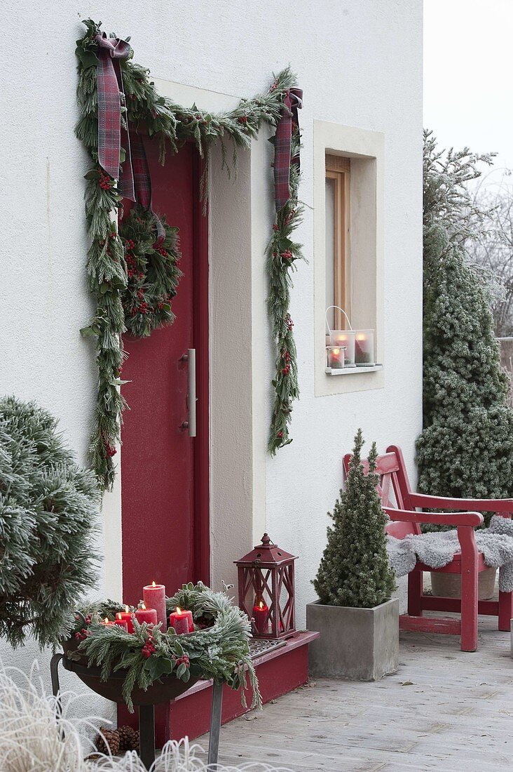 Entrance decorated with Christmas-garland and Ilex wreath