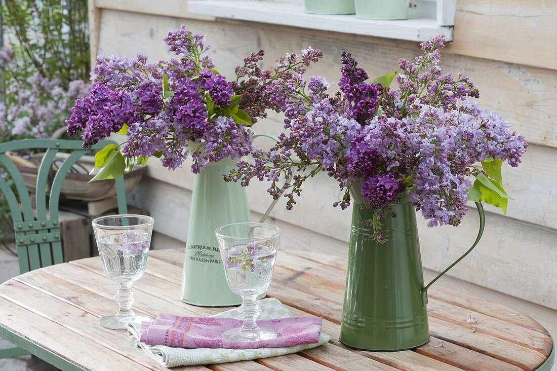 Fragrant spring Syringa bouquets in green tin cans