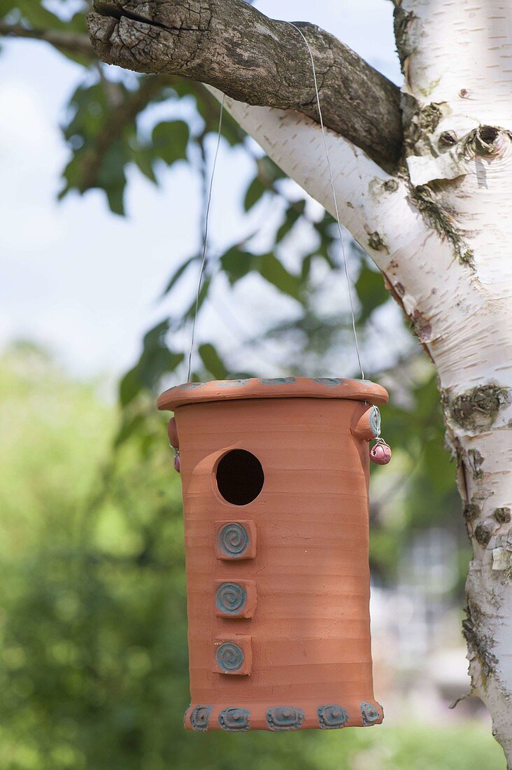 Handgetöpferter Nistkasten für Meisen am Baum