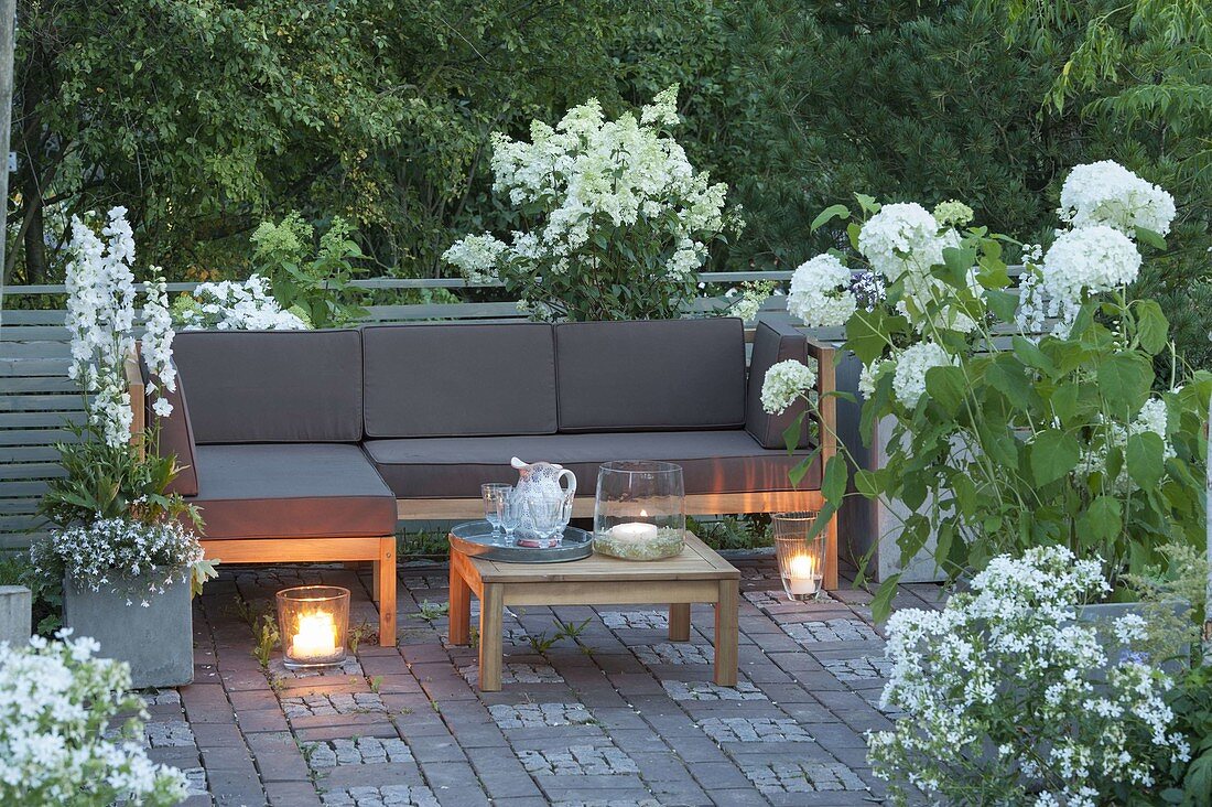 Terrasse mit weissen Pflanzen, Lounge-Ecke und Tisch, Hydrangea 'Annabelle'