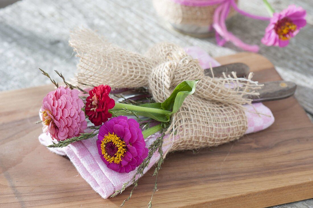 Small bouquet of zinnia and grasses as napkin deco