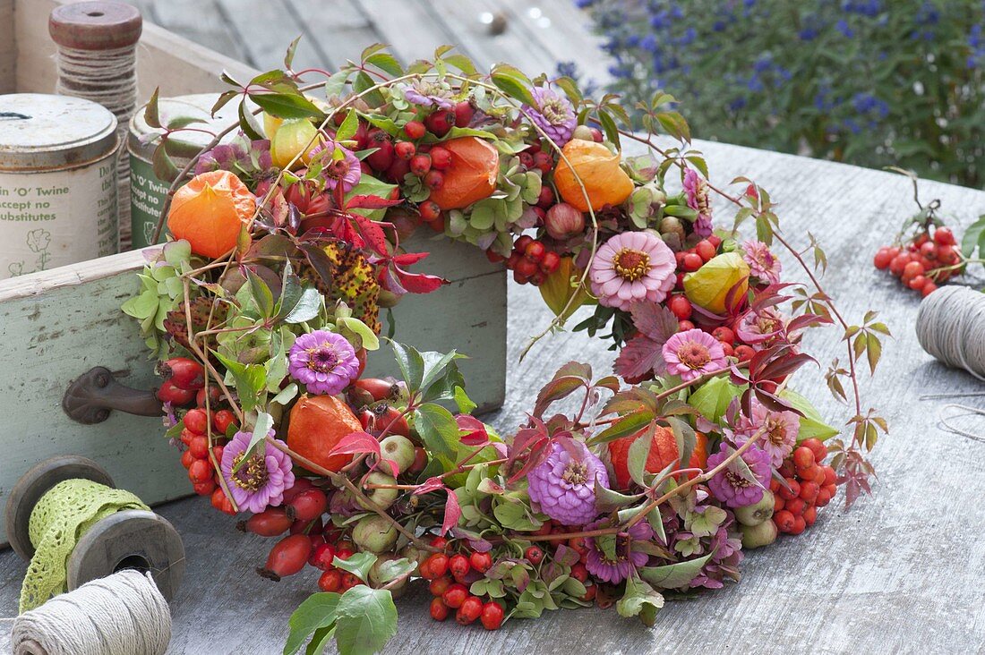 Herbstlicher Kranz aus Zinnia (Zinnien), Rosa (Hagebutten), Vogelbeeren