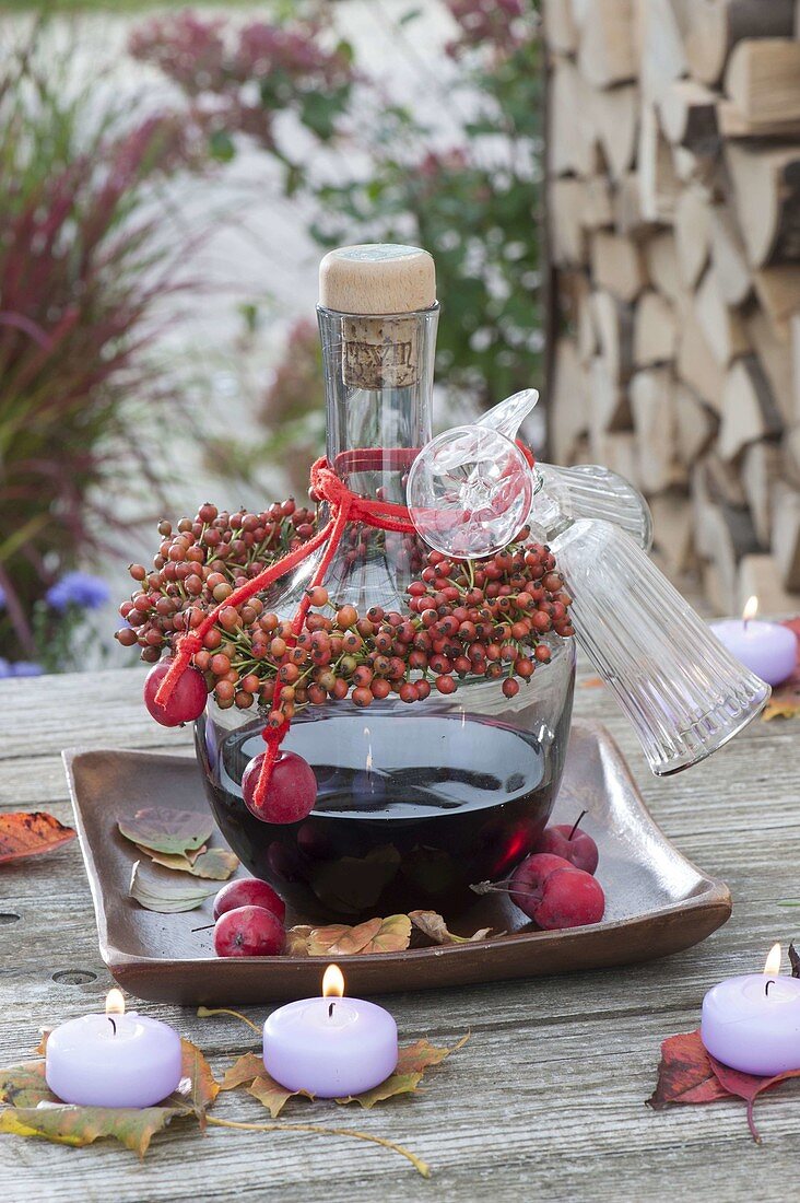 Flasche mit Rotwein-Likör als Geschenk mit Kränzchen aus Hagebutten