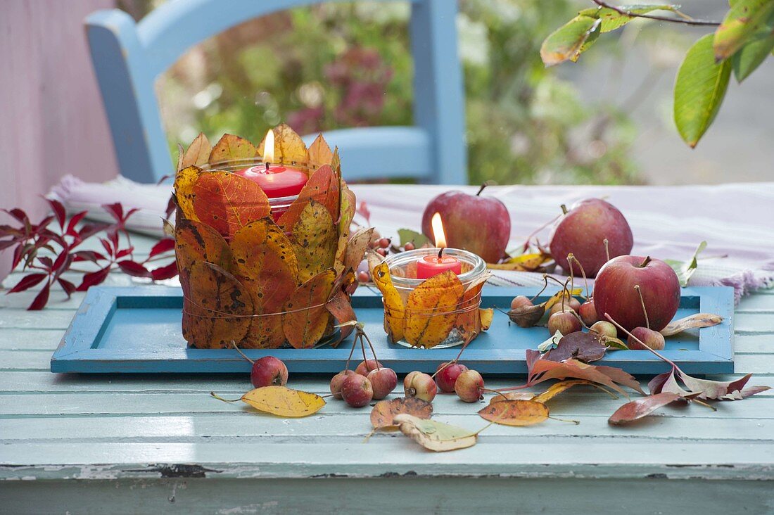 Herbst-Tischdeko mit Blätter-Windlichtern und Äpfeln