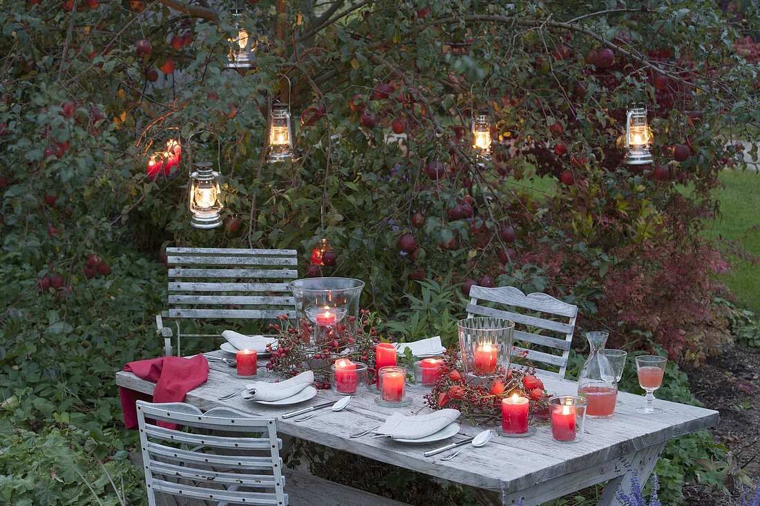Herbst-Tischdeko mit Windlichtern in Kränzen aus Zweigen von Rosa