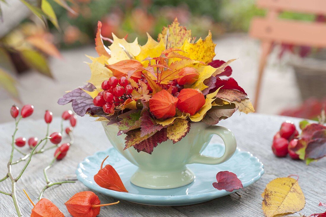 Kleiner Herbststrauss in Tasse auf Untersetzer