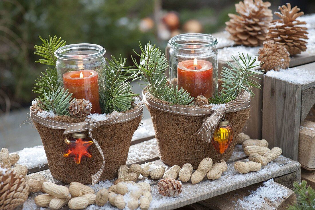 Preserving jars as lanterns in coconut pots, decorated with twigs