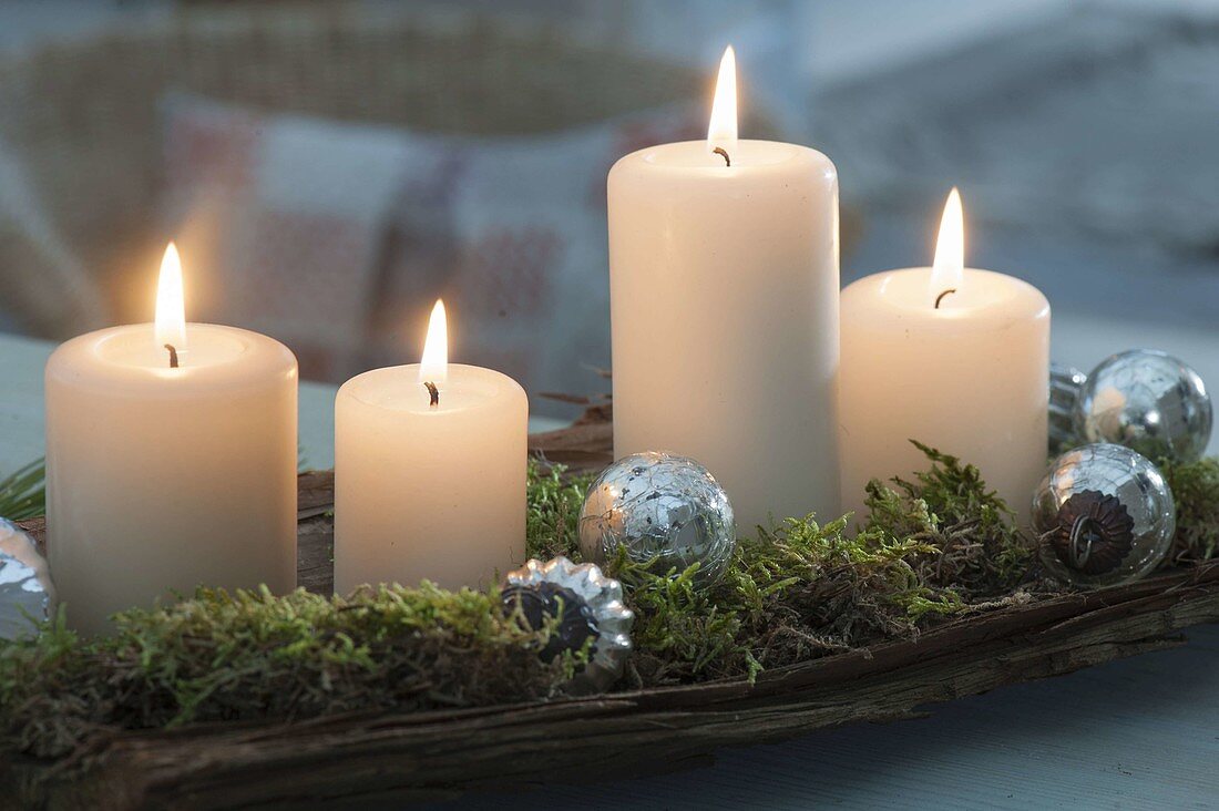 Schlichte Advents-Deko mit 4 Kerzen auf Rinde, dekoriert mit Moos