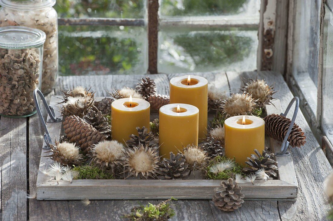 Fast, natural Advent decoration with yellow candles on wooden tray