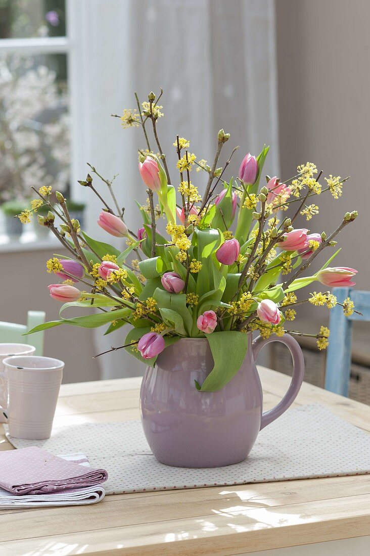 Strauss aus Cornus mas (Kornelkirsche) und Tulipa (Tulpen) in Keramik-Krug