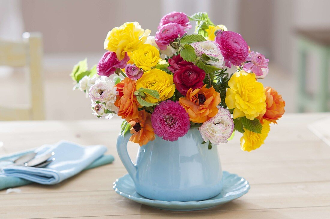 Small bouquet of colorful mixed ranunculus with branches