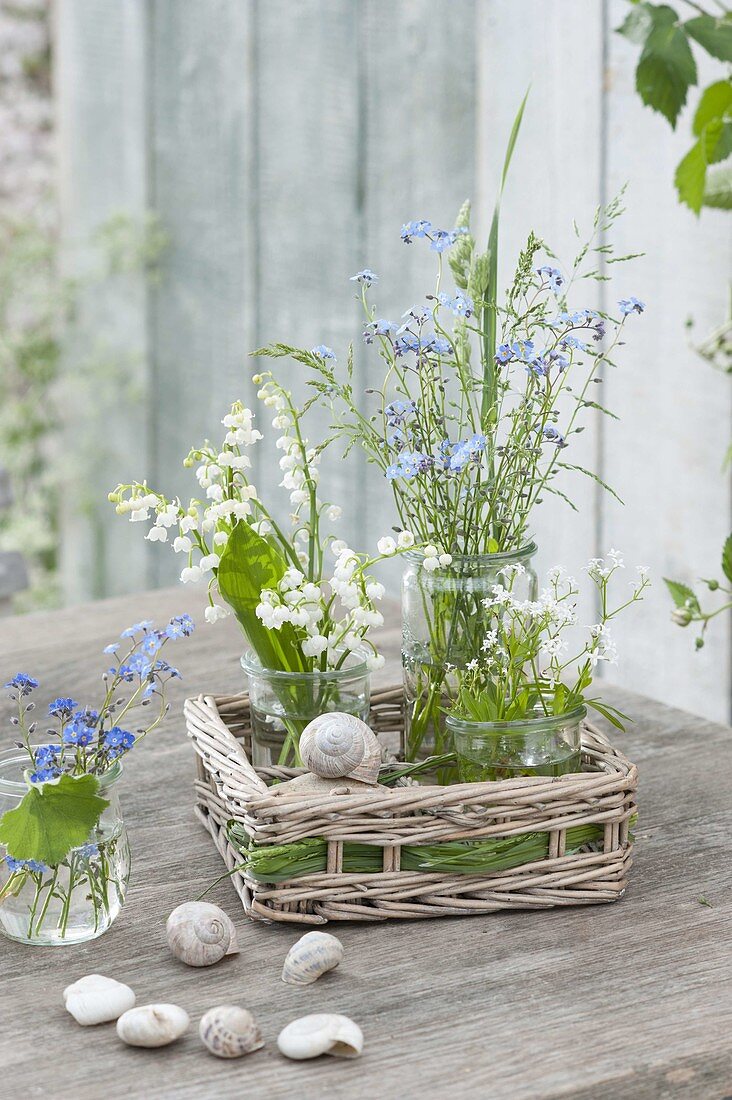 Small bouquets in preserving jars placed in basket
