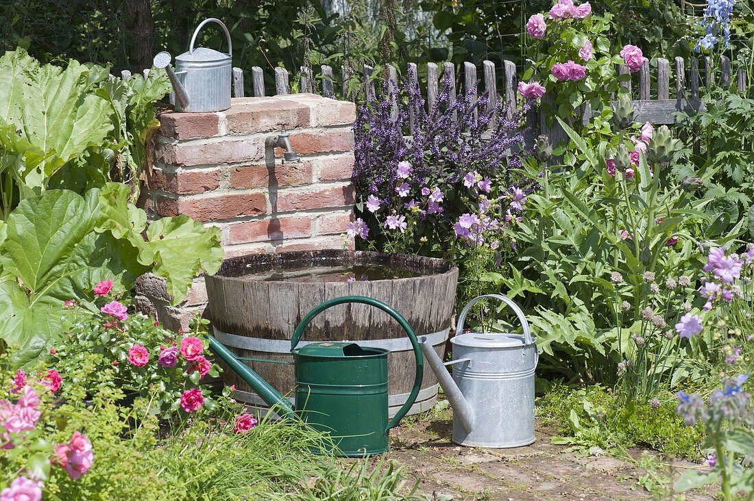 Wasserfass und Wasserhahn für die Bewässerung im Bauerngarten