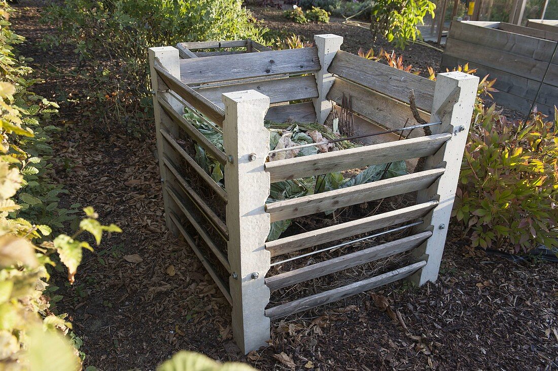 Composter with concrete posts and boards, path with bark mulch
