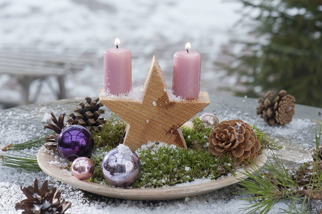 Flat bowl with wooden star, candles, moss, baubles