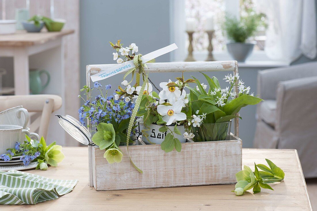 Spring greeting in wooden basket, small bouquets of wild garlic