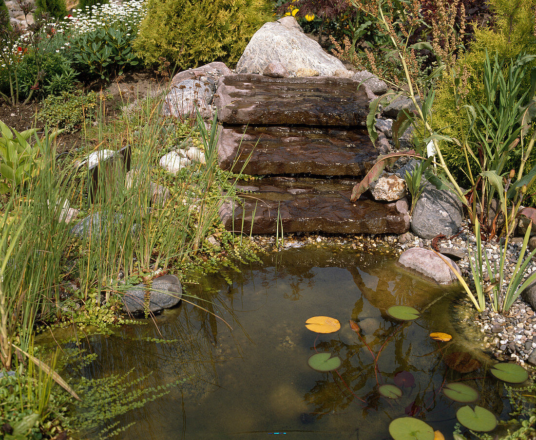 Pond with small artificial stream maed with stone bowls