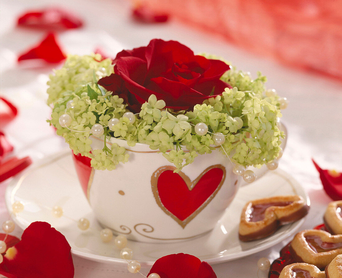 Valentinsgruß mit Herztasse gefüllt mit Rose