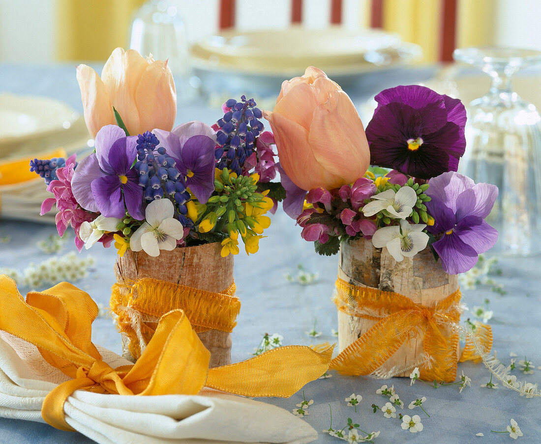 Glasses with bark wrapped with viola pansies, muscari