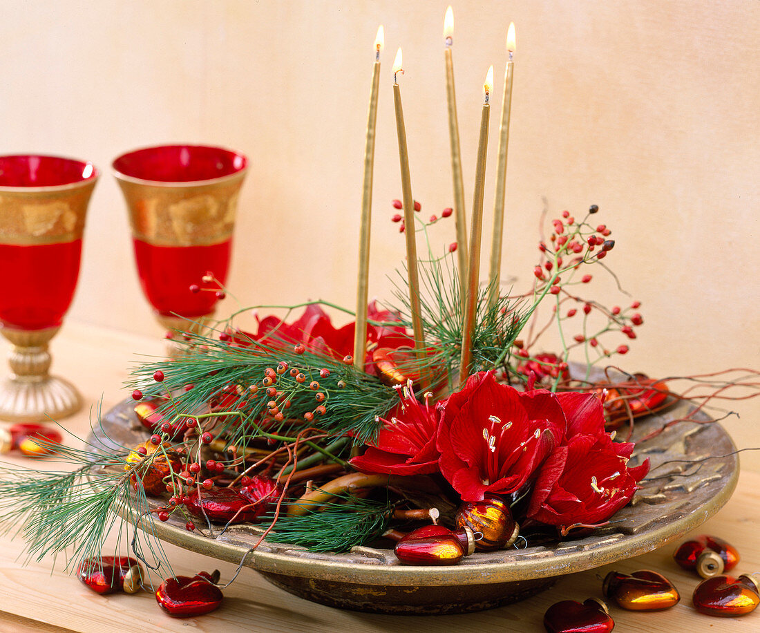 Christmas arrangement with amaryllis, twigs and berry decorations
