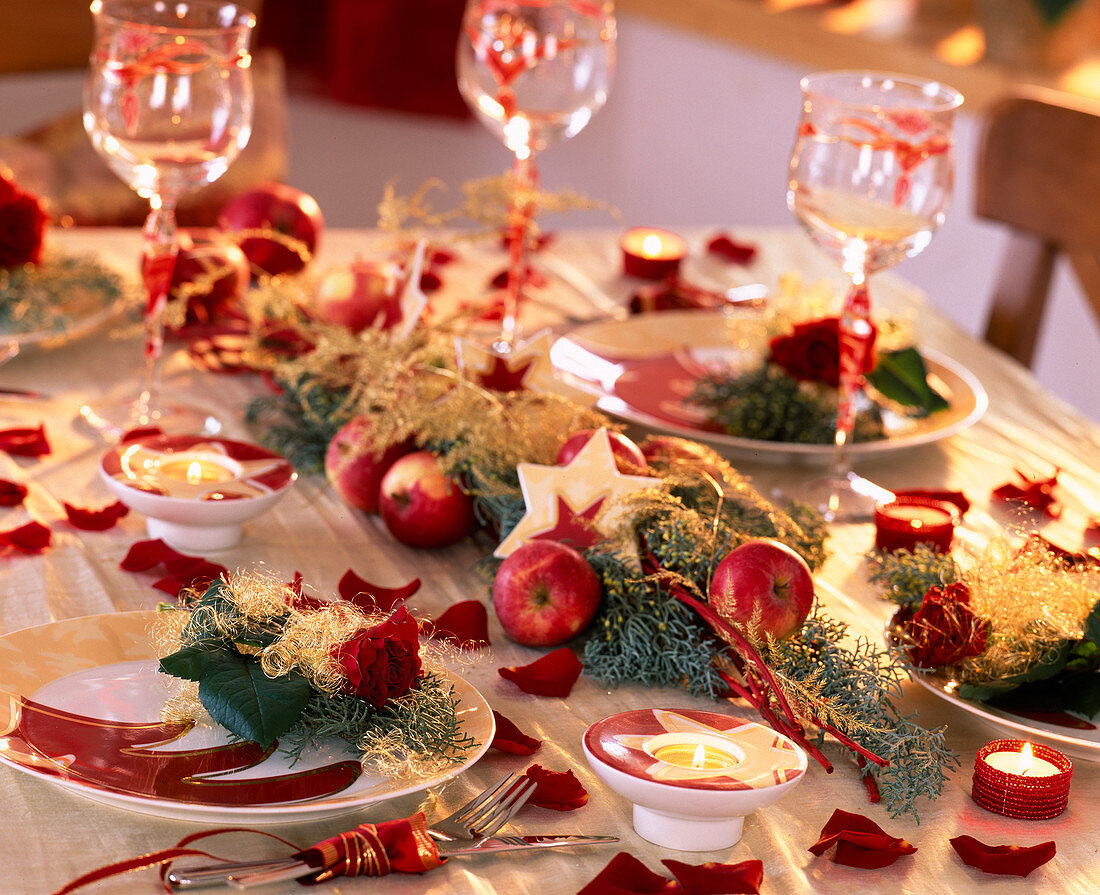 Weihnachtliche Tischdeko mit Rosen, Äpfeln und Sternen