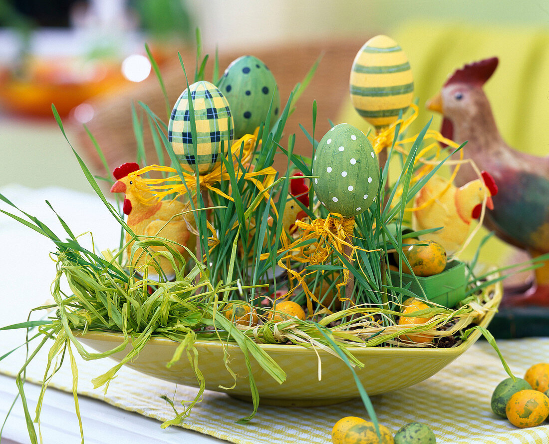 Osterschale mit Weizengras, Eiern, Hühnchen und Bast