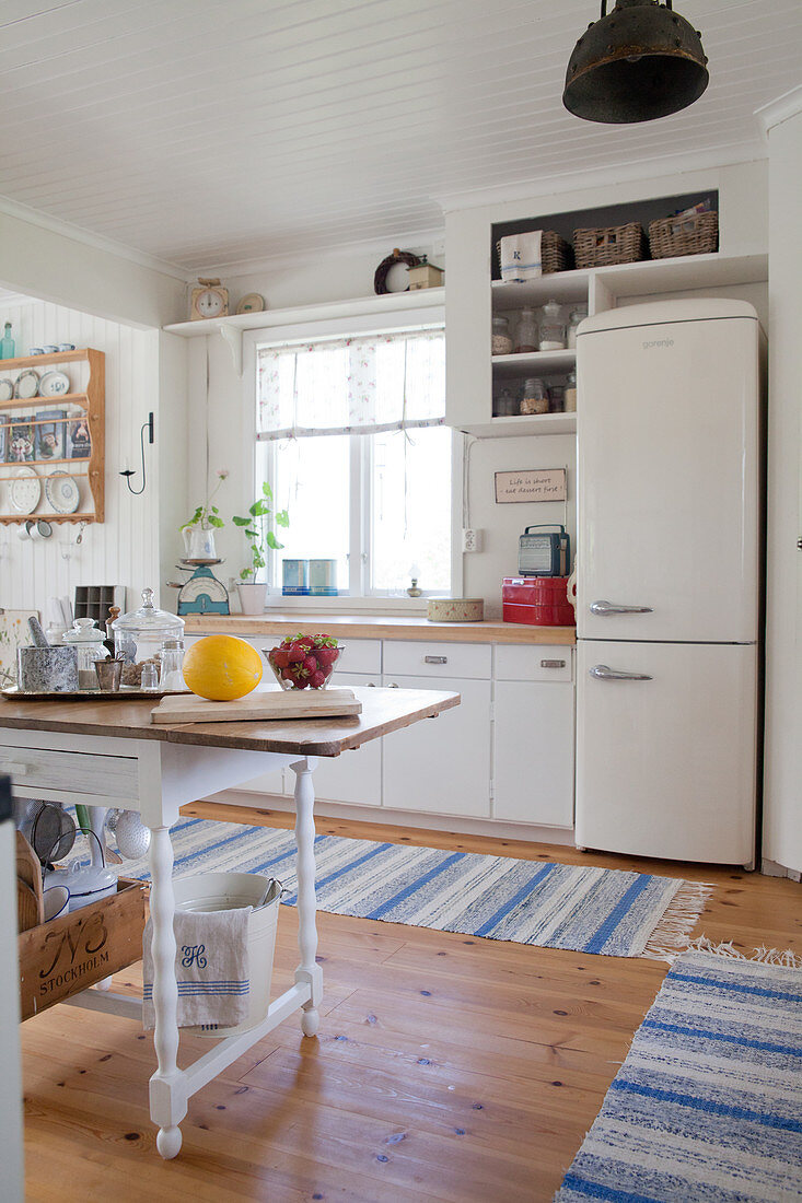 Retrokühlschrank in der Landhausküche mit blau gestreiften Läufern