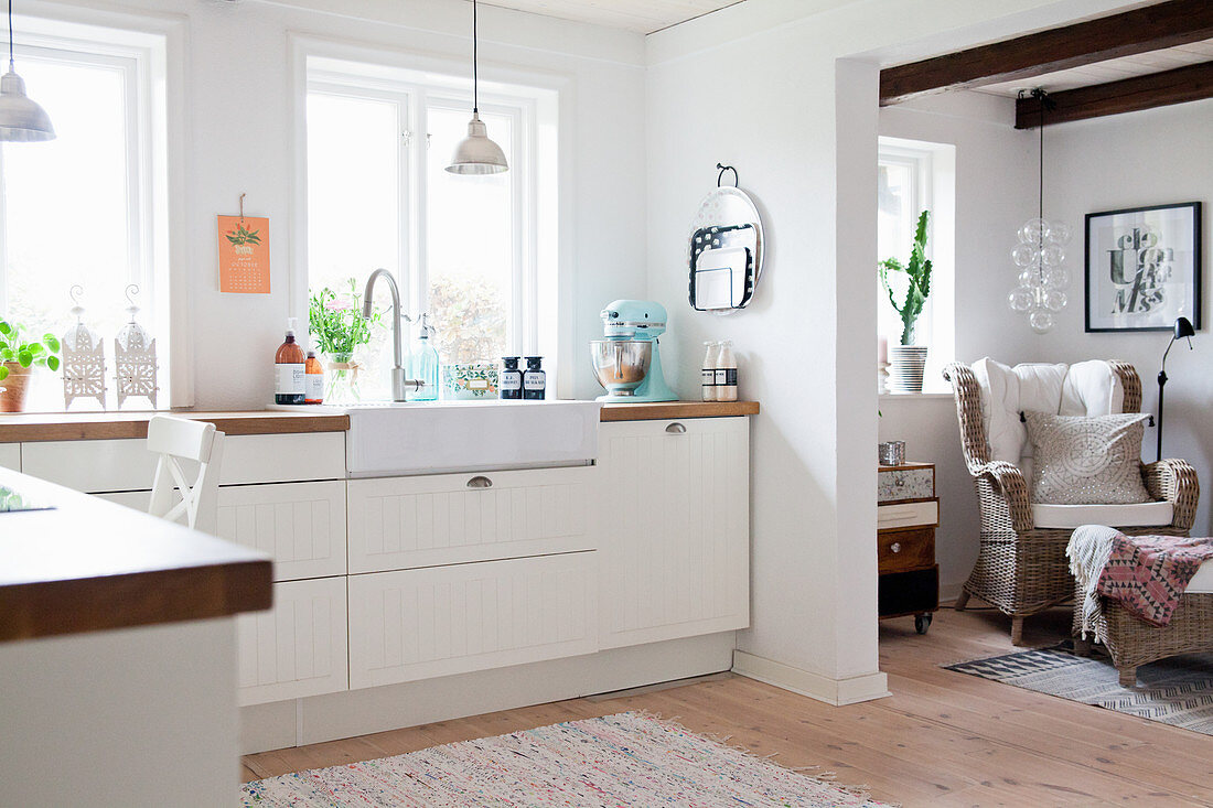 White fitted kitchen with open doorway leading into living room