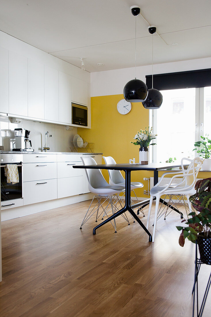 Modern dining table in kitchen-dining room with yellow wall