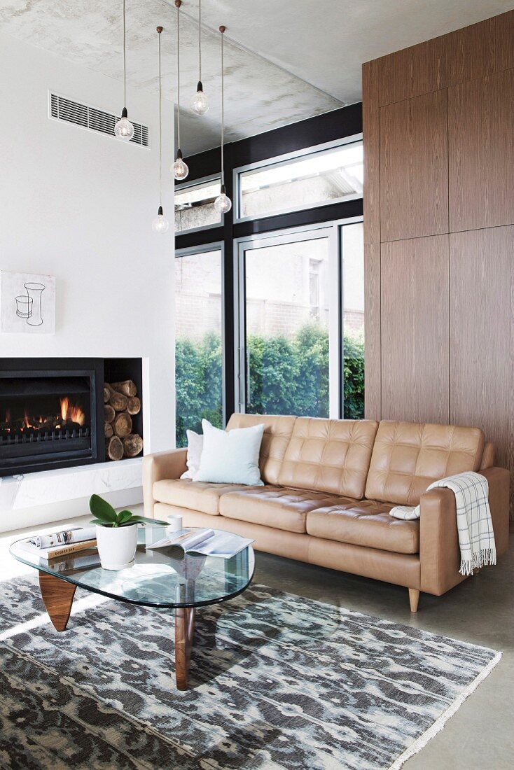 Beige leather room and retro coffee table in the living room with fireplace
