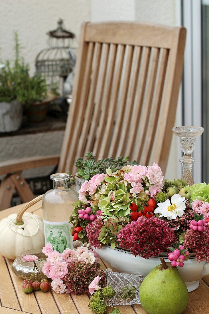 Arrangement of autumnal flowers in tureen on garden table
