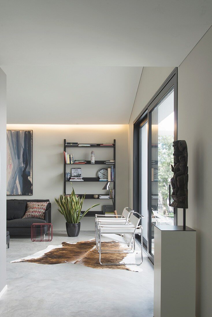 Modernes Wohnzimmer in Grau und Schwarz mit Kuhfellteppich