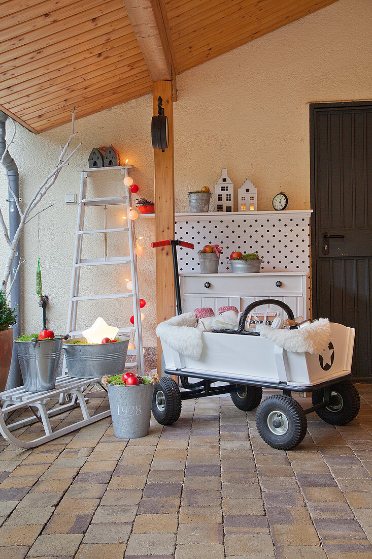 Bollerwagen und Weihnachtsdeko unter dem Vordach