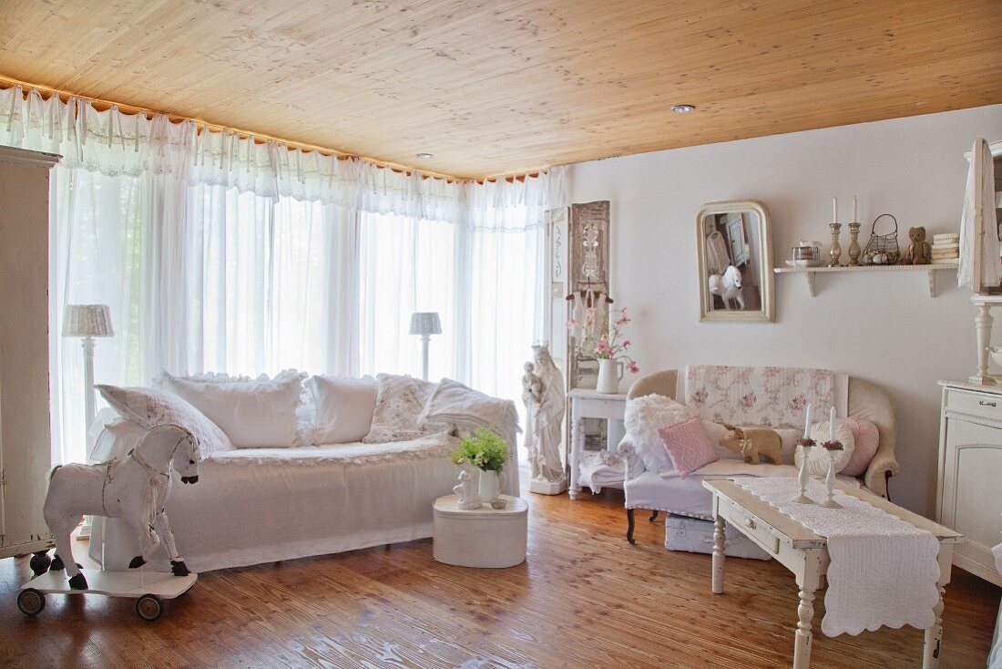 Wohnzimmer mit zwei Sofas und Holzpferd in Shabby Stil