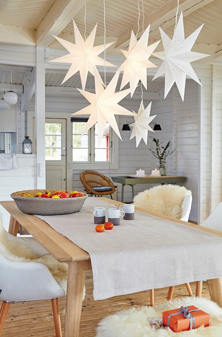 Several paper stars hanging over the dining table in a wooden house