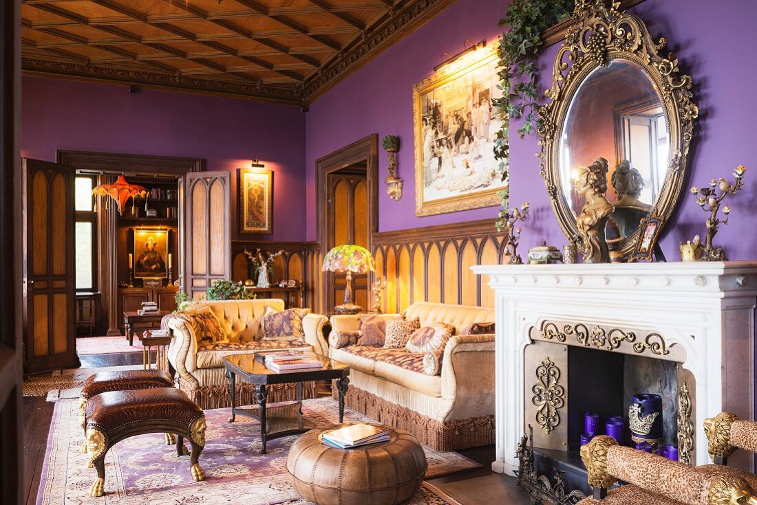 Kassettendecke und violette Wände in Schloss mit Stilmöbeln und offenem Kamin