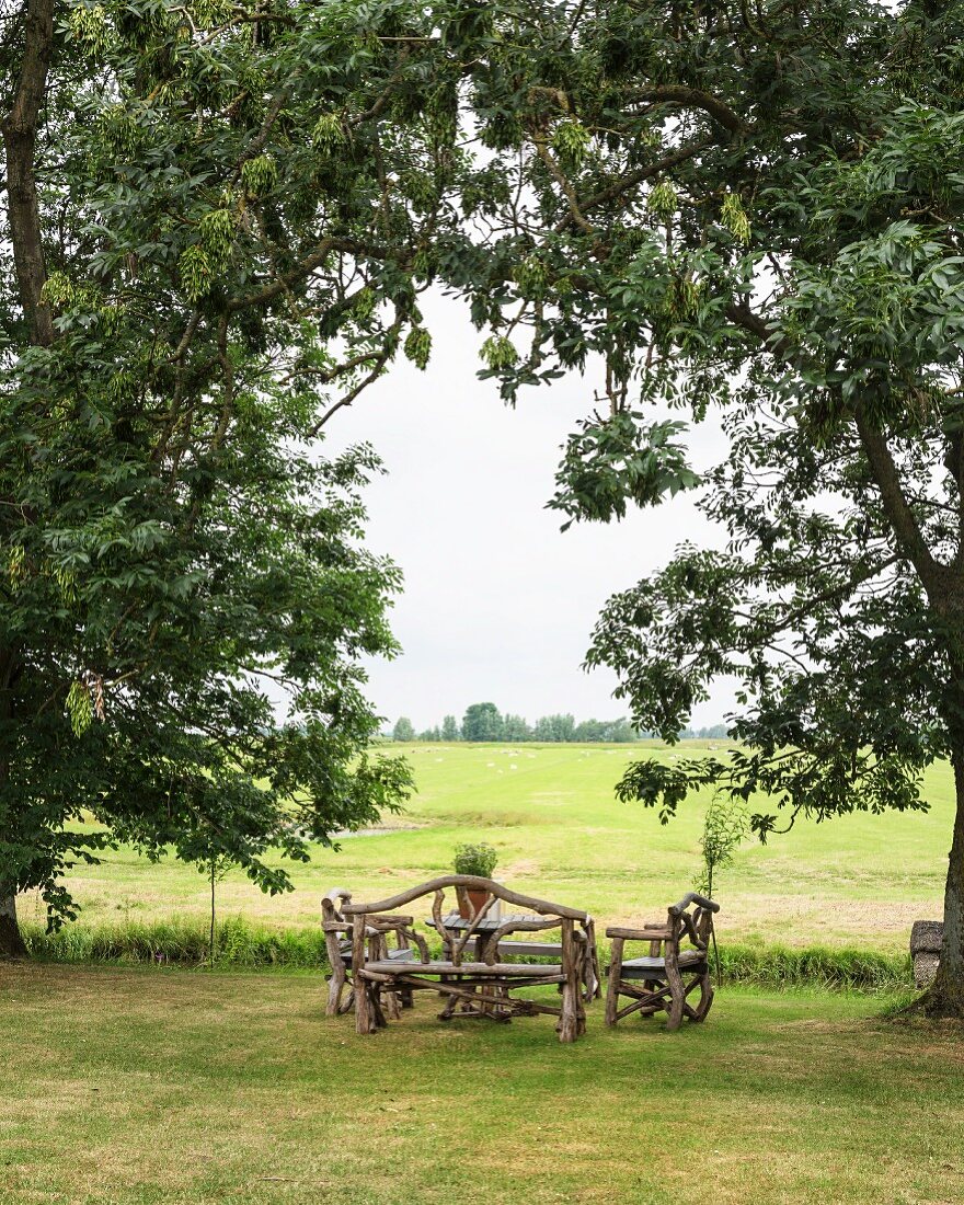Rustikale Gartenbänke auf Wiese, Blick auf friesische Landschaft