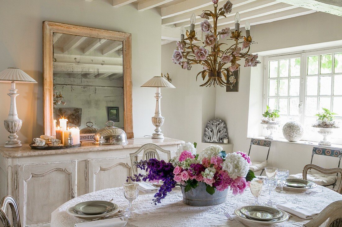 Esszimmer mit sommerlichem Blumenschmuck auf gedecktem Tisch