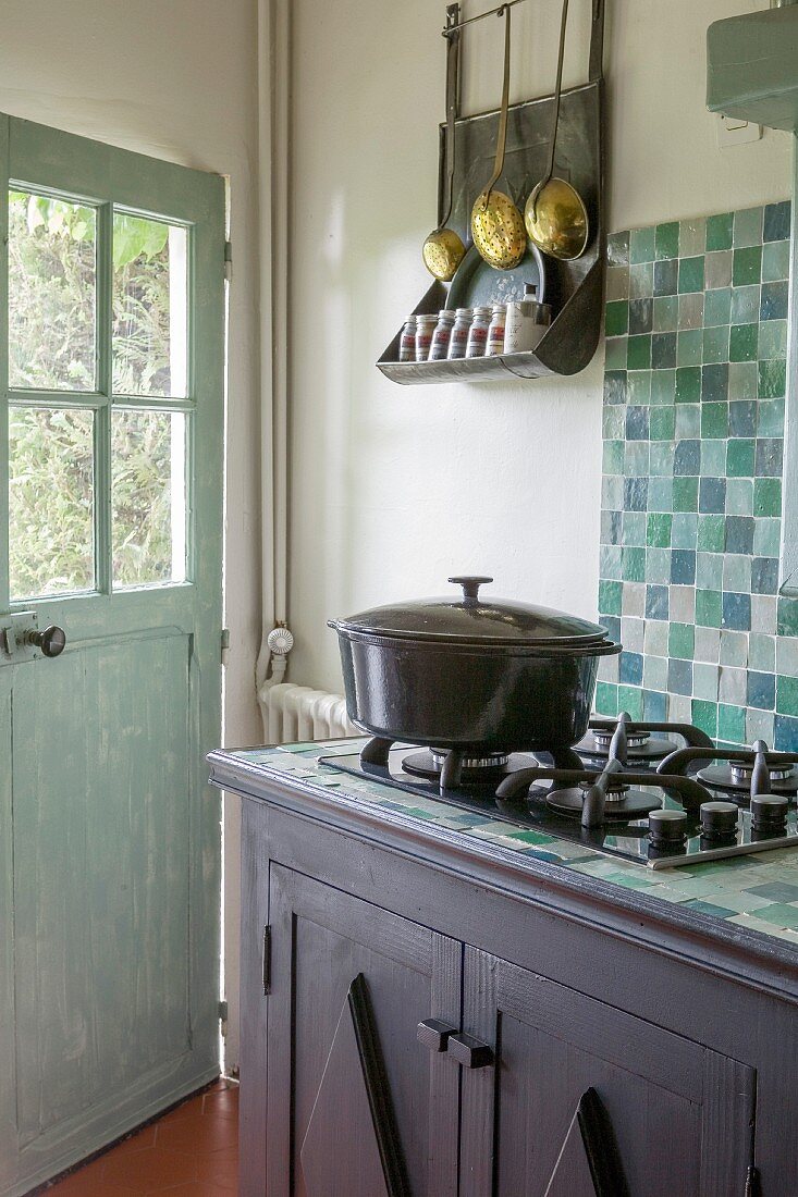 Vintage-style country-house kitchen with turquoise wall tiles and gas hob