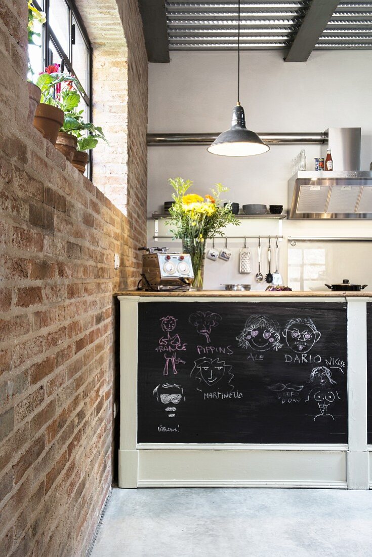Sideboad with chalkboard back wall in open-plan kitchen
