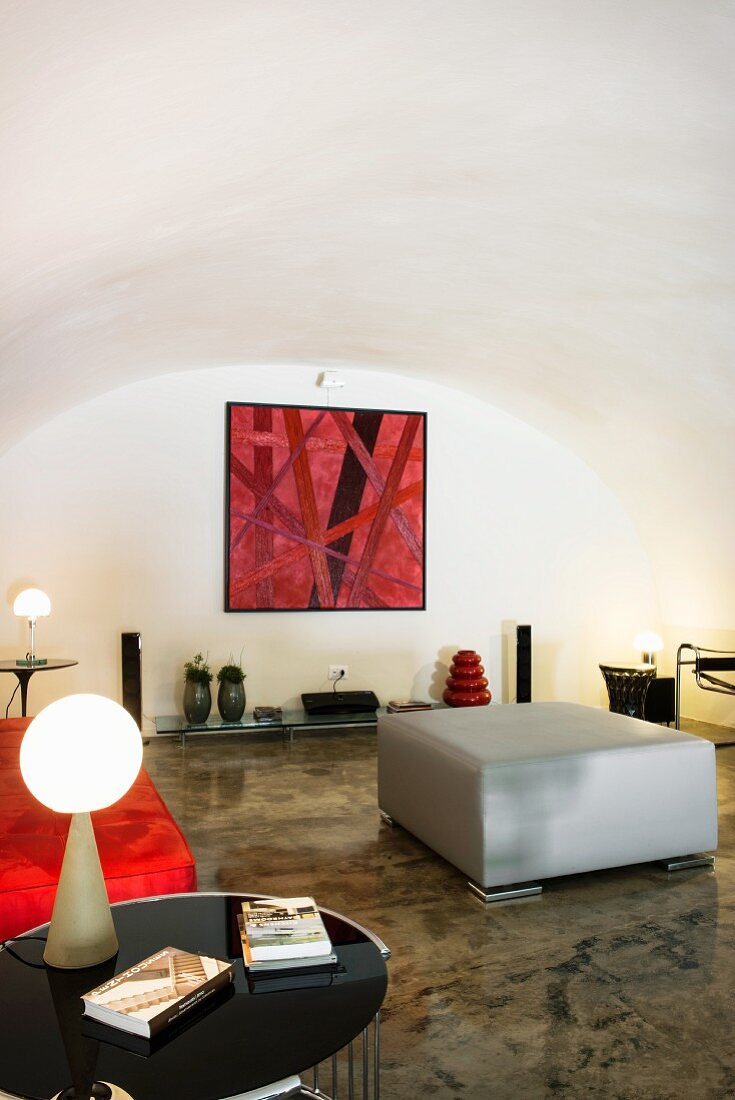 Restored white vaulted ceiling and glossy concrete floor in designer living area