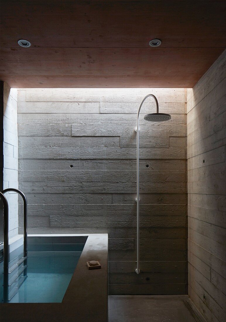 Bad mit Betonwänden und Wanne aus Beton im Stil des Brutalismus