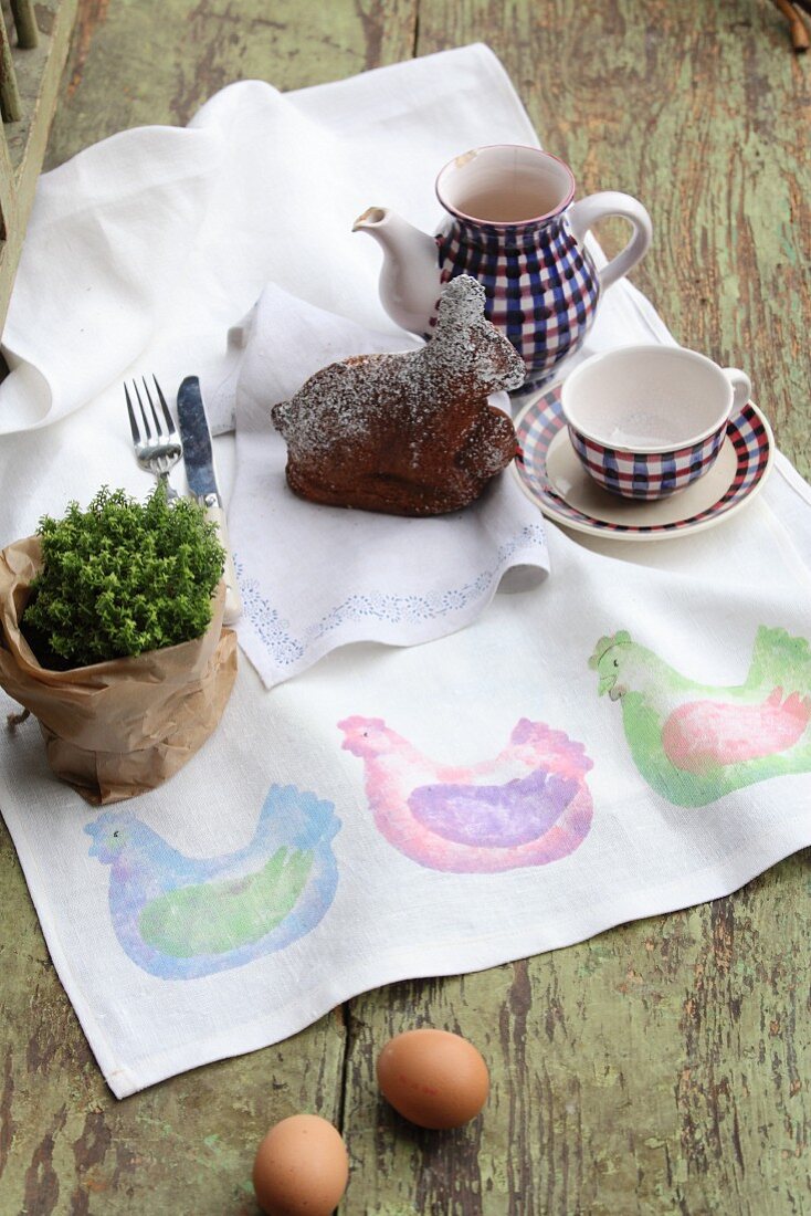 Hand-made table runner with pattern of hens, potted plant, cake and coffee set