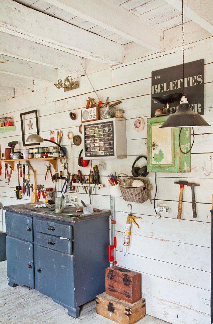 Various tools hung on wooden wall in workshop