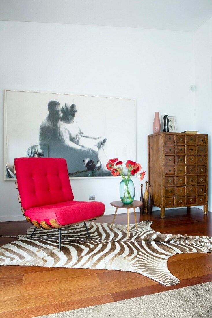 Red designer easy chair on zebra-skin rug