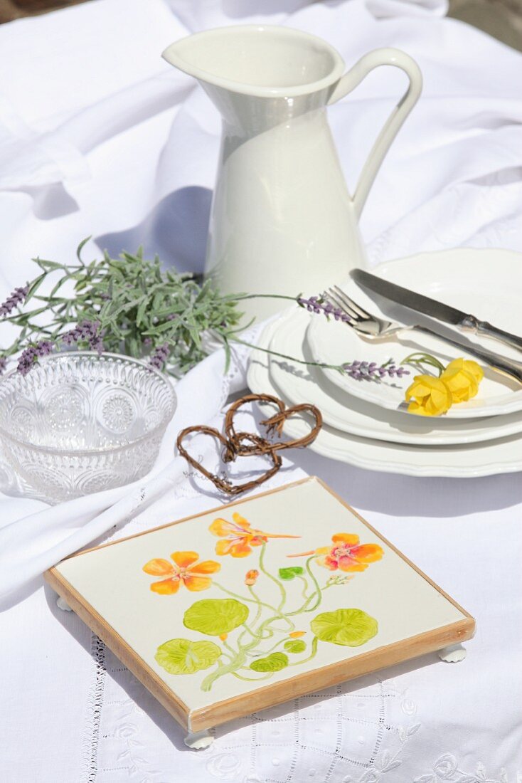 Coaster painted with floral motif on white tablecloth